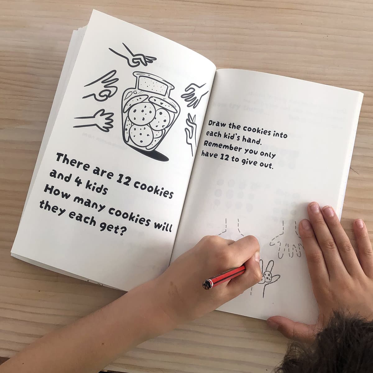 A kid writing answers in the cookies math activity